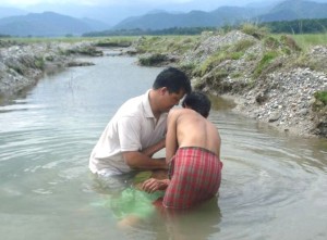 A pastors in India baptizing a new convert.